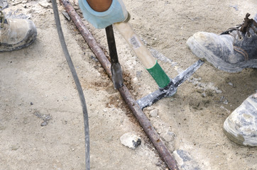 worker while splitting the concrete with the jackhammer during the renovation of a roof