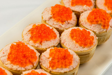 Tartlets with cheese and red caviar. Selective focus. Copy space