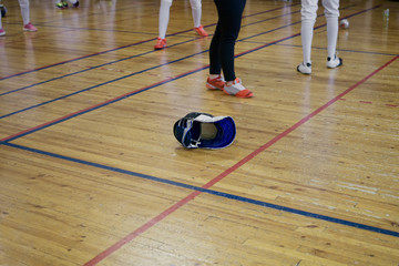 Fencing helmet mask lies in the middle of the gym during fencing competitions