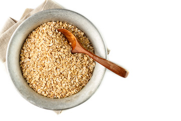 dry oatmeal flakes in metal bowl on white background. Isolated. Top view. Copyspace