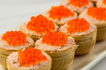 Tartlets with cheese and red caviar. Selective focus. Copy space