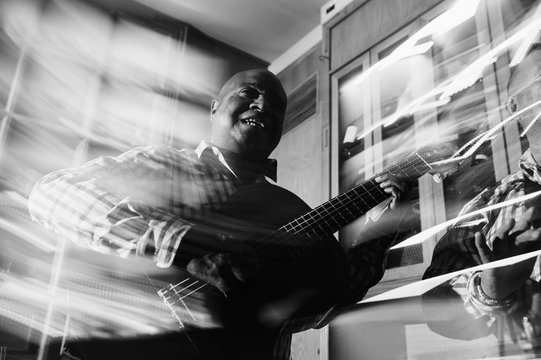 musician playing guitar in in the night club