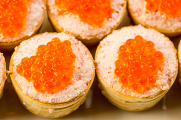 Naklejka na ściany i meble Tartlets with cheese and red caviar. Selective focus. Copy space