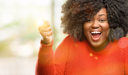 Beautiful african woman happy and surprised cheering expressing wow gesture, outdoor