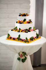 Rustic white wedding cake decorated with fruits