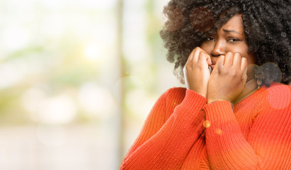 Beautiful african woman terrified and nervous expressing anxiety and panic gesture, overwhelmed,...