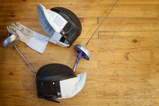 Fencing mask, gloves, swords and epees lie on the floor in the fencing gym - Powered by Adobe