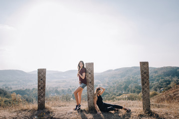 Beautiful young girls walk on autumn mountain slopes, fun, jump. female friendship