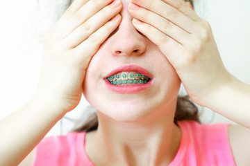 Girl embarrassed and closes the face with her hands.