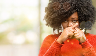 Beautiful african woman annoyed with bad attitude making stop sign with hand, saying no, expressing...