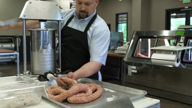 Butcher preparing a sausage with a sausage stuffer