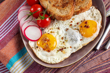 Healthy simple breakfast with bread toast, fried eggs and vegetables