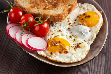 Healthy simple breakfast with bread toast, fried eggs and vegetables