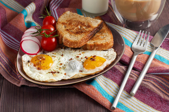 Healthy simple breakfast with bread toast, fried eggs and vegetables