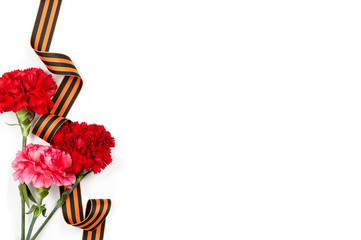 Concept background of May 9 russian holiday Victory Day. Red carnations and St. George's ribbon