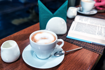 coffee with milk and opened book