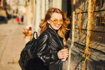 Pretty girl stand on the street with cup of coffee