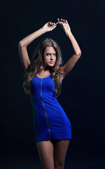 portrait of a dancing woman in a short dress, black background