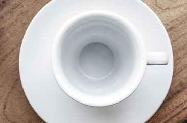 white coffee cup and plate on old wooden table,top view