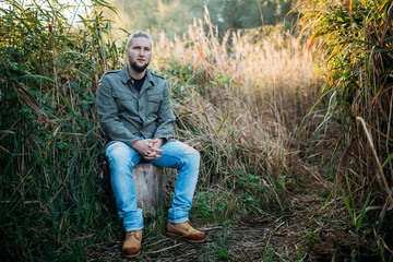 Obraz premium Portrait of a young guy with a beard in nature.
