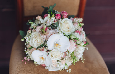 Wedding bouquet on a vintage chair. Orchid, rose. Country style.