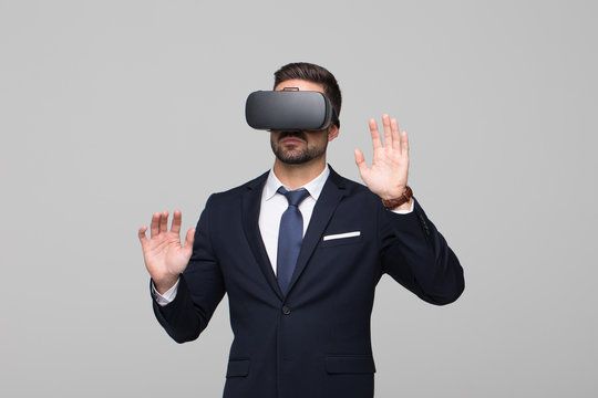 Young businessman in VR headset touching imaginary interface