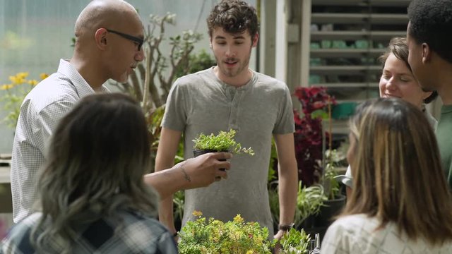 Man chatting to small group of people about plant.