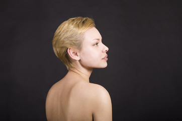 Portrait of blonde girl on dark background.