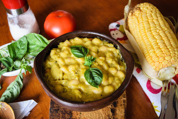 Classical Chilean food white beans in corn sauce in a clay bowl closeup. Porotos con mazamorra in spanish.