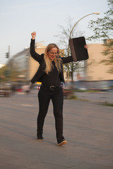 Mujer de negocios con los brazos en alto celebrando su éxito profesional.