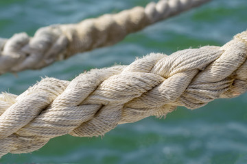 Fototapeta premium Large and strong yarn ropes against the background of sea water