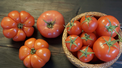 Beef tomatoes, pink tomatoes on black barn wood background.