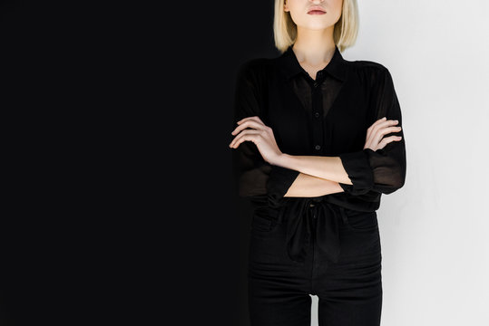 cropped image of stylish blonde woman in black clothes standing with crossed arms