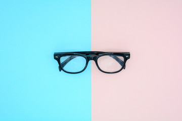 black glasses on blue and pink background