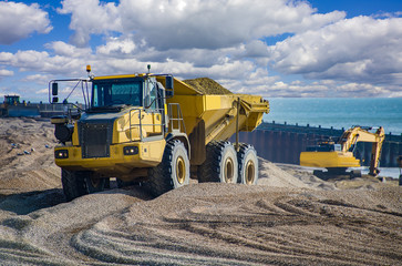 Construction - Heavy Machinery Construction Site - Engineering - Sea Defence. Large plant machinery being use to build the beach sea defence at Seaford, East Sussex, UK