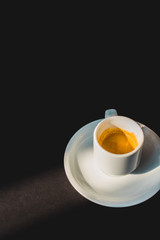 cup of tasty coffee in white cup on black surface