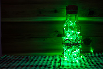 Green light Christmas lamp on wood background.