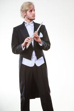 Male flutist wearing tailcoat holds flute