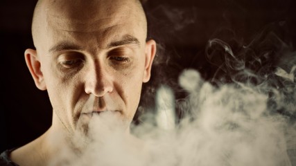 Bald young man vaping