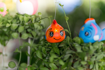 Plant in potted with hanging ceramic dolls  in the park