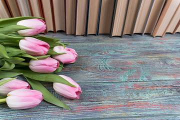 Pink tulips with books on wooden background