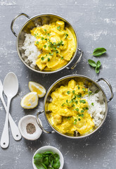 Salmon curry and rice in curry dishes on grey background, top view. Indian cusine style. Flat lay