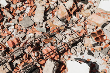 Debris of a demolished wall, demolition junk, broken concrete and pieces of masonry brick.
