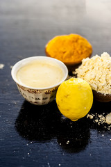 Chana,haldi,limbo ka ubtan or ayurvedic face pack of Turmeric, Lemon, and gram flour on wooden surface for good skin and no acnes or pimples.