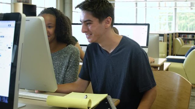 Female and a male student studying together with a computer