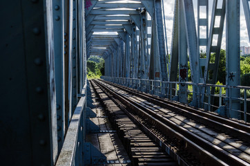 The railway bridge at sunset is illuminated by bright light