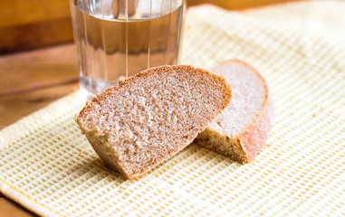 A piece of rye bread against the background of a glass of vodka