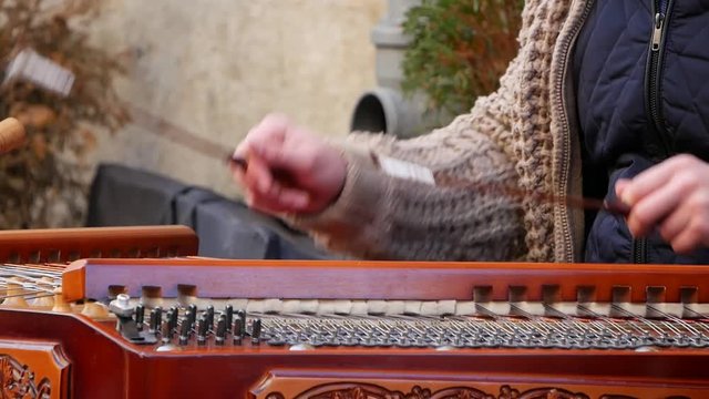 Playing the dulcimer folk musical instrument from Europe, playing the cymbals, cymbal, a young man playing cymbals, dulcimer musical instrument, Hutsul cymbals,Carpathian dulcimer