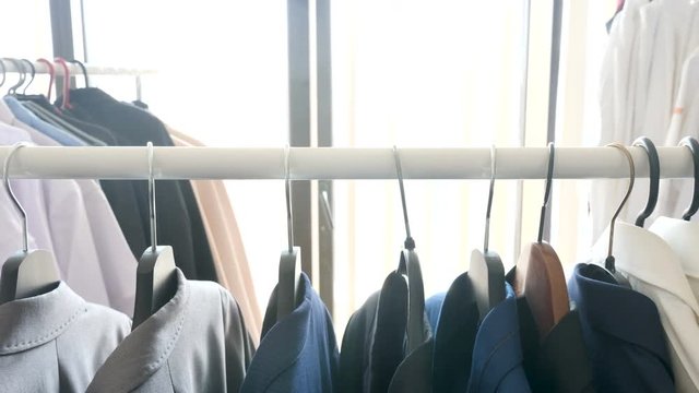 Solly footage of hanger in a store with male business clothes on it