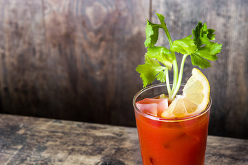 Bloody Mary cocktail in glass on wooden table.Copyspace
